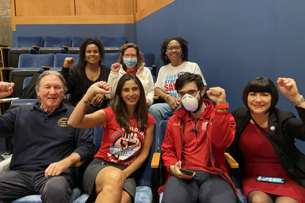 CWA members seated at the hearing with their fists up