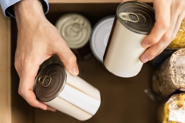 hands putting cans in a box 