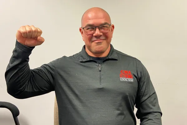 Judiciary steward in a CWA shirt, smiling with his fist up 