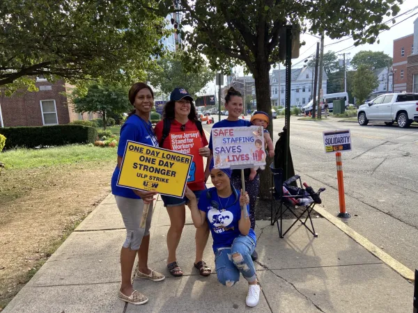 Striking nurses and CWA members pose for a picture on the picket line