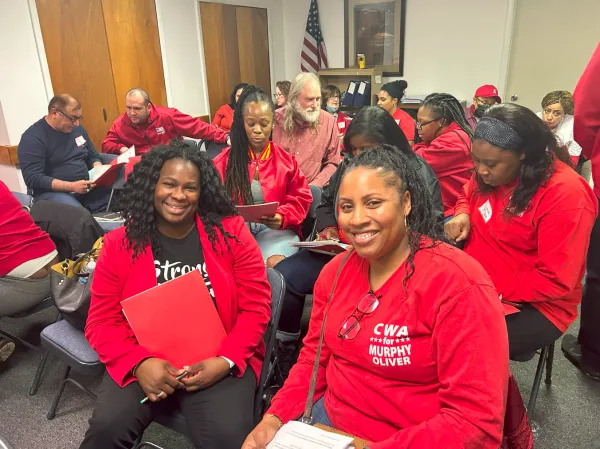 Two CWA stewards in red smiling at the camera