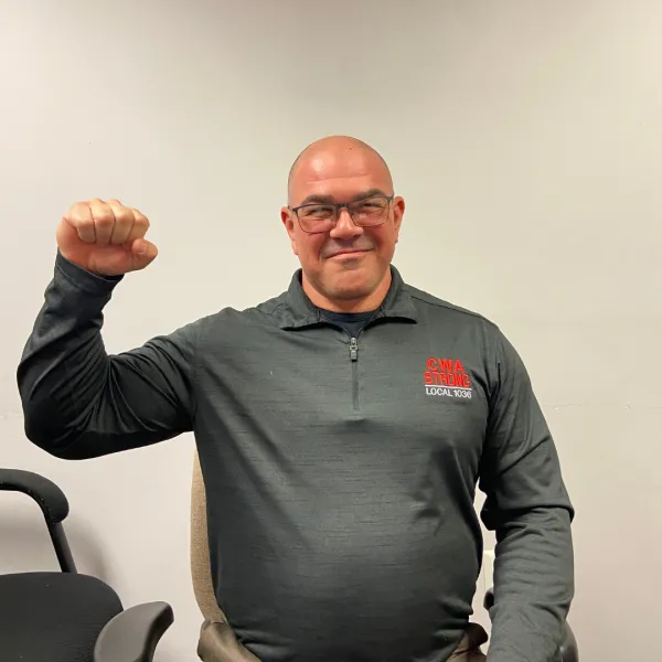 Judiciary steward in a CWA shirt, smiling with his fist up 