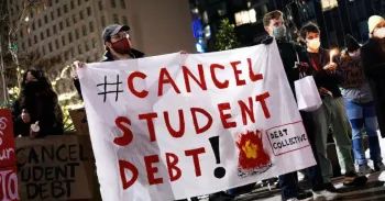 Protestors holding a sign that reads "Cancel Student Debt"