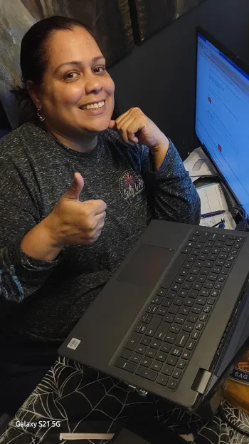 Member working from home at her laptop and giving a thumbs up